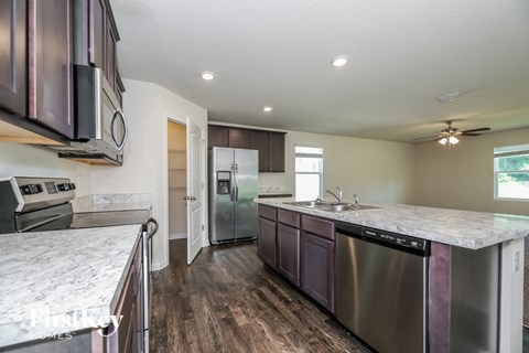 A kitchen with a stainless steel dishwasher and a white countertop.
