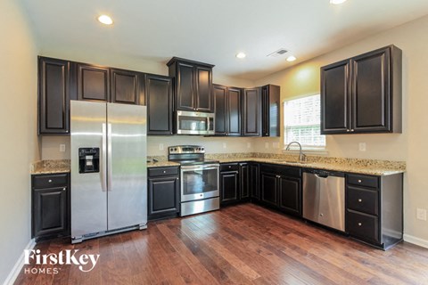 a kitchen with black cabinets and stainless steel appliances