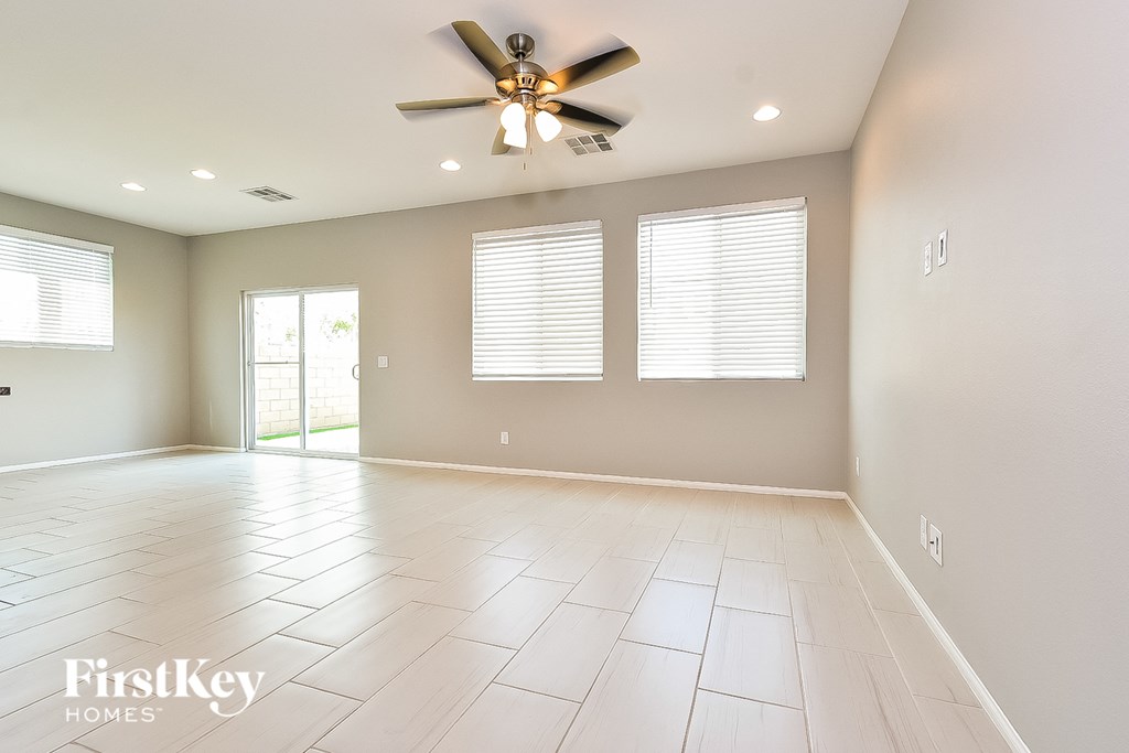A spacious room with a ceiling fan and tiled flooring.