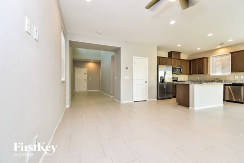 A spacious kitchen with a breakfast bar and a hallway leading to another room.