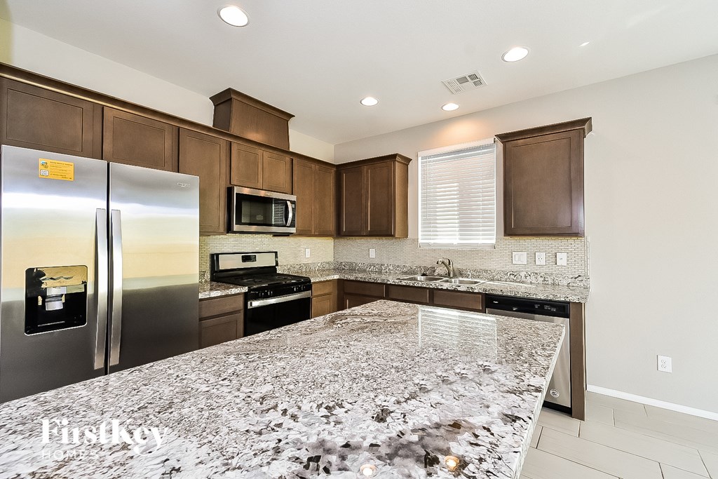A kitchen with granite countertops and stainless steel appliances.