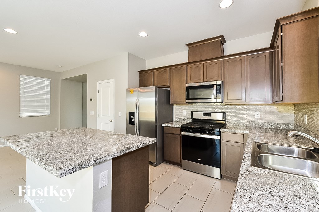 A kitchen with granite countertops and stainless steel appliances.