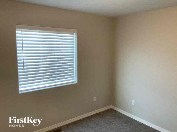 an empty room with a window and a carpet