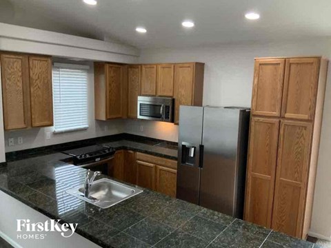 A kitchen with wooden cabinets and a stainless steel refrigerator.