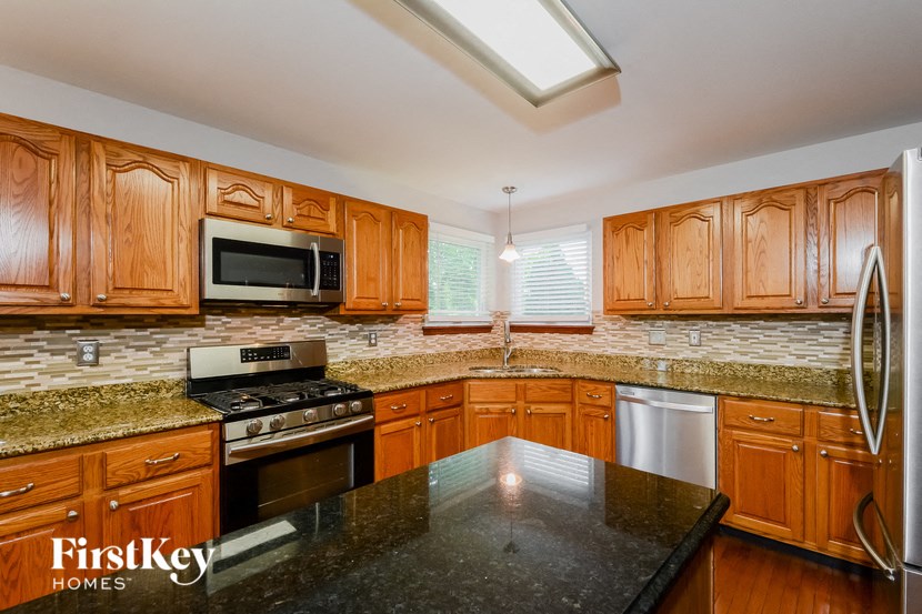 a kitchen with wooden cabinets and granite counter tops and stainless steel appliances
