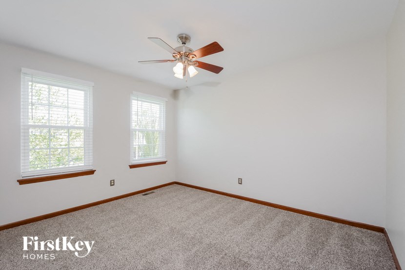 the living room of an empty house with a ceiling fan