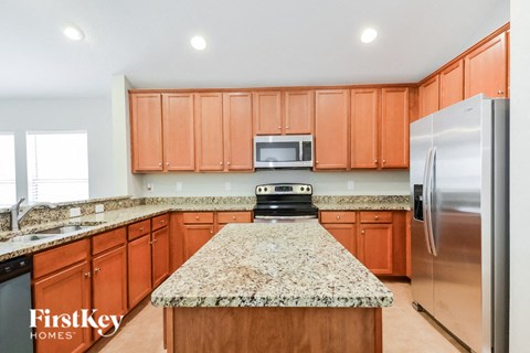 a kitchen with granite counter tops and wooden cabinets