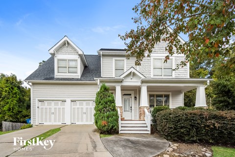 a white house with white shutters and a driveway