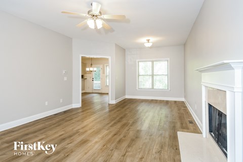 a living room with a fireplace and a ceiling fan
