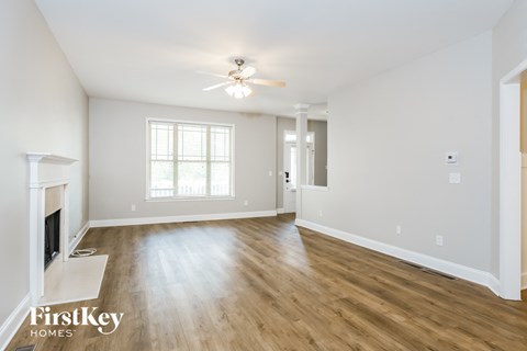 a living room with a fireplace and a ceiling fan