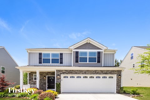 A modern two-story house with a garage and a front porch.