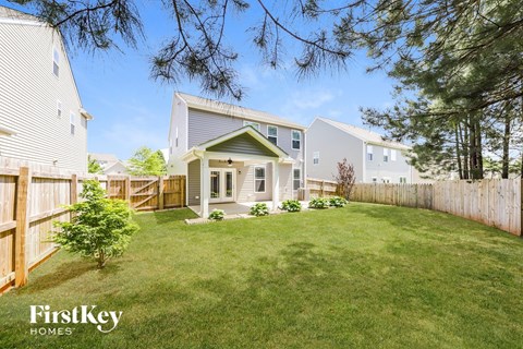 A house with a lawn and trees in the background.