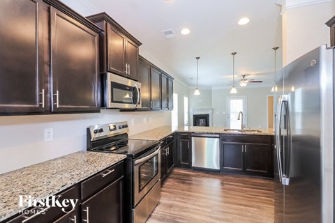 A kitchen with dark wood cabinets and stainless steel appliances.