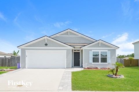 a blue house with a lawn and a white garage door