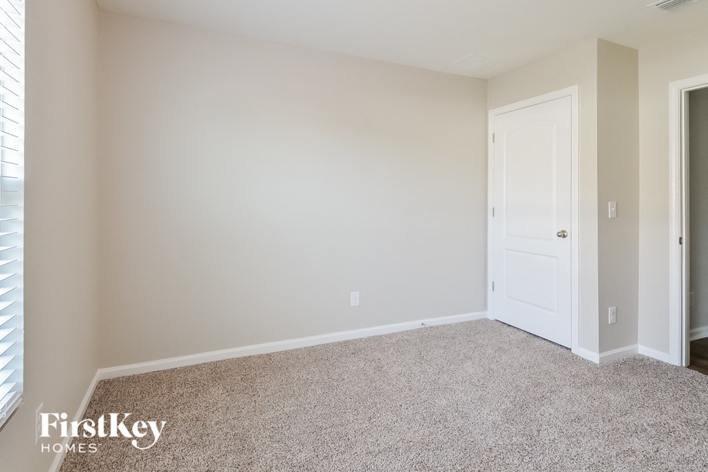 a bedroom with a carpeted floor and a white door