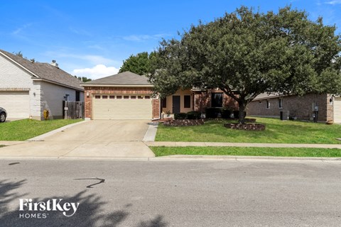 A tree in front of a house with a sign that says FirstKey Homes.