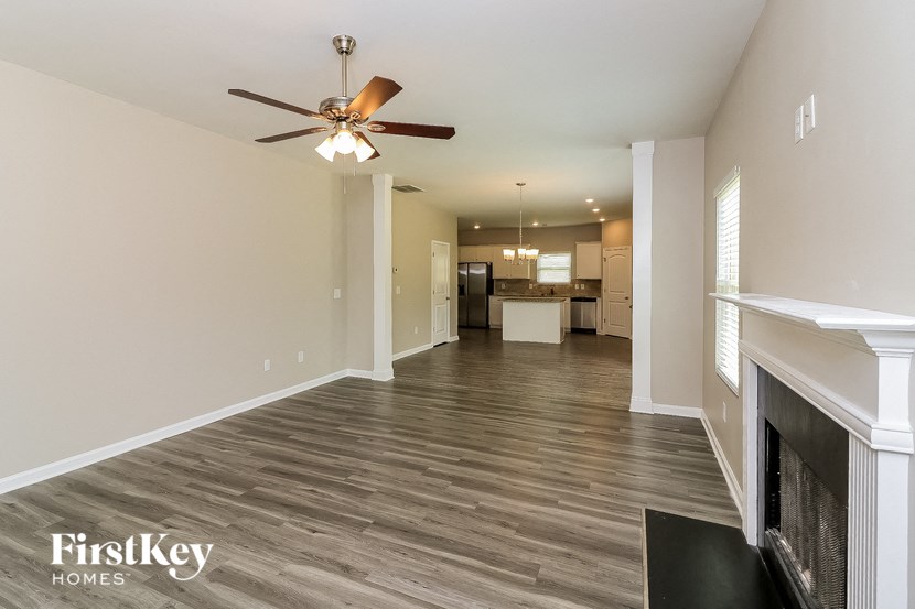 a living room with a fireplace and a ceiling fan