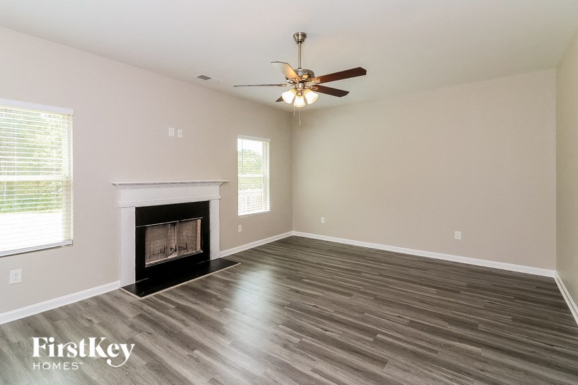 a living room with a fireplace and a ceiling fan