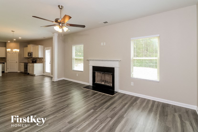 a living room with a fireplace and a ceiling fan