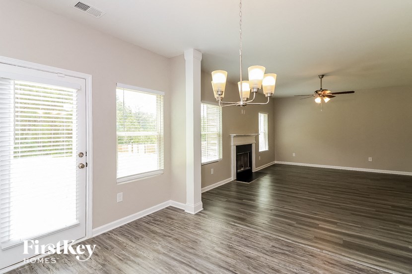 an empty living room with a fireplace and a ceiling fan