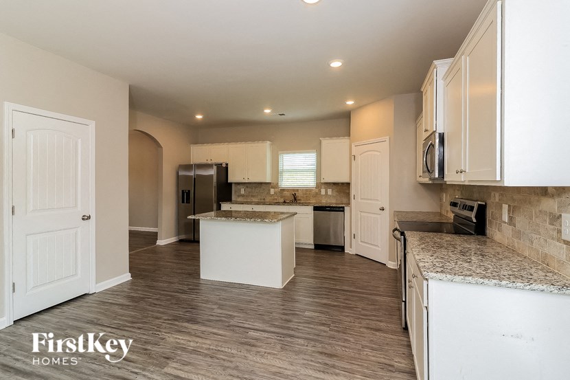 a large kitchen with white cabinets and granite counter tops