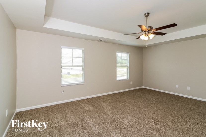 a room with carpet and a ceiling fan