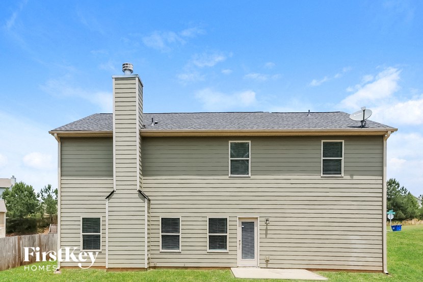 the front of a gray house with a blue sky in the background