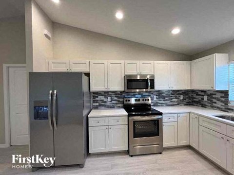 a kitchen with stainless steel appliances and white cabinets