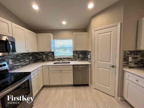 a kitchen with white cabinets and a sink