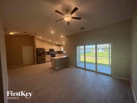 a large empty living room with a ceiling fan