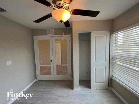 a empty room with a ceiling fan and a door