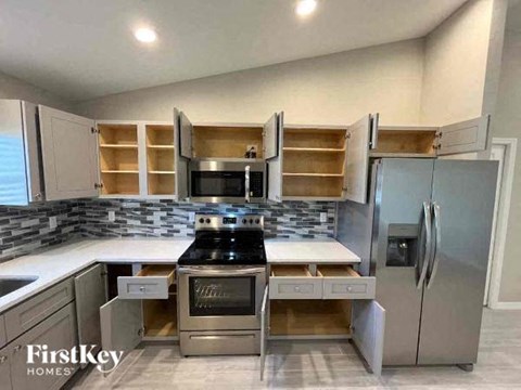 A kitchen with a stove top oven and a refrigerator.