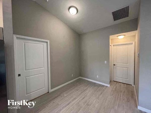 A room with a white door and a wooden floor.