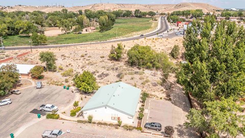 an aerial view of a green roofed building with a highway in the background
