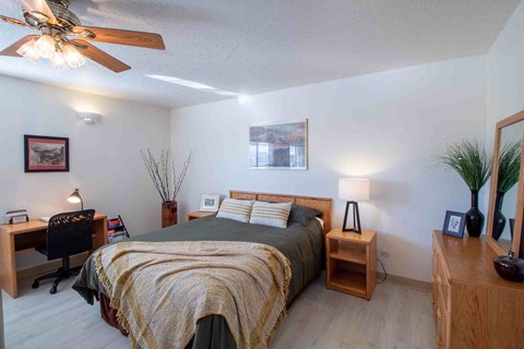 a bedroom with a bed and a ceiling fan