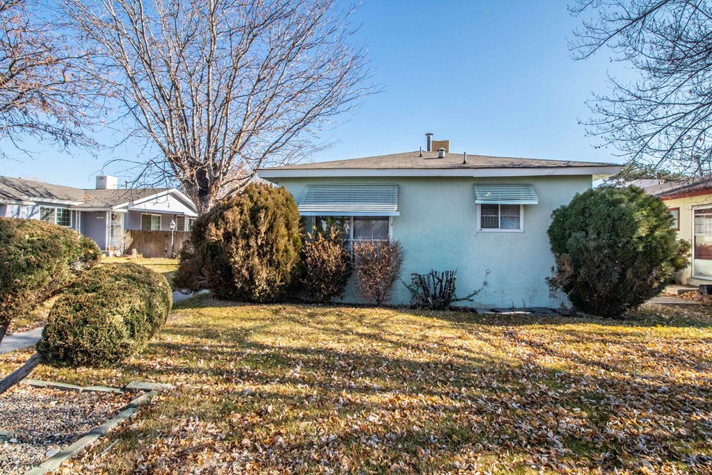 the front of a house with a yard and some bushes