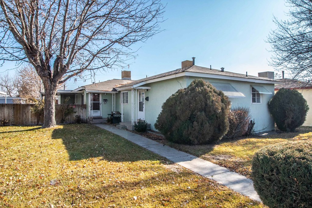 a white house with a yard and a tree