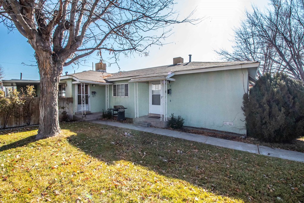 a white house with a yard and a tree