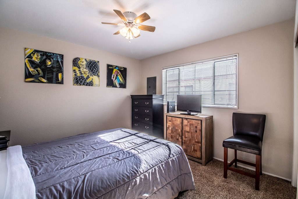 the master bedroom has a bed and a dresser with a tv