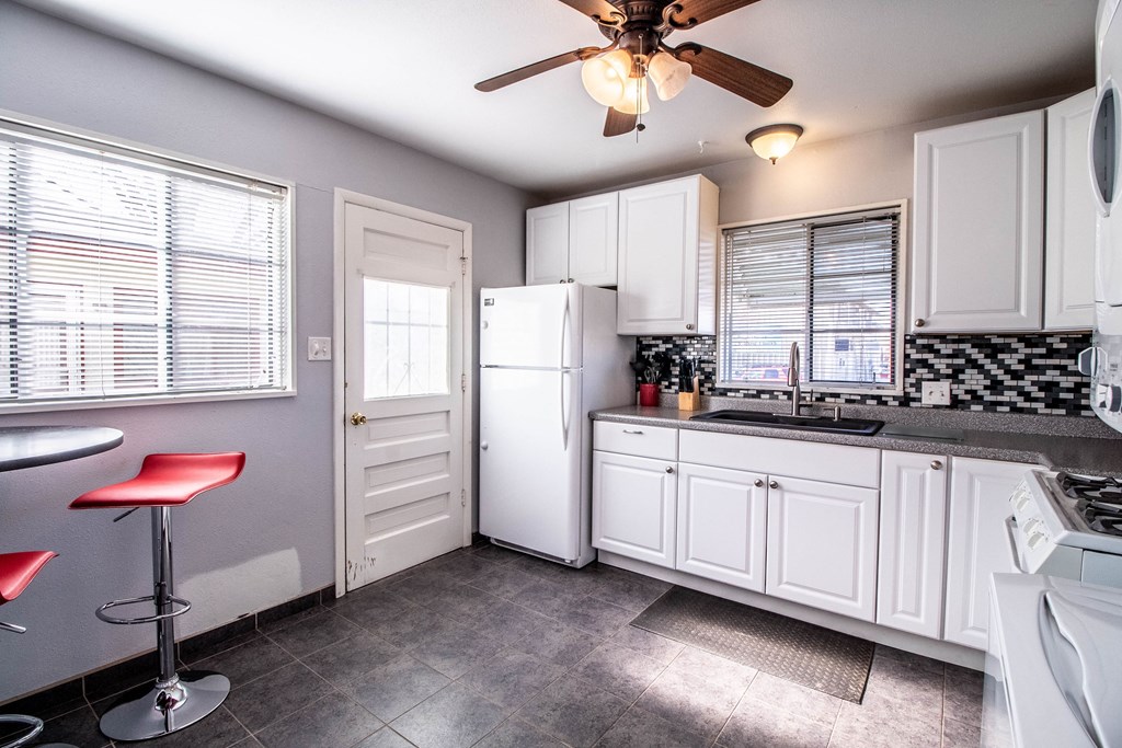 a kitchen with white cabinets and a sink and a refrigerator