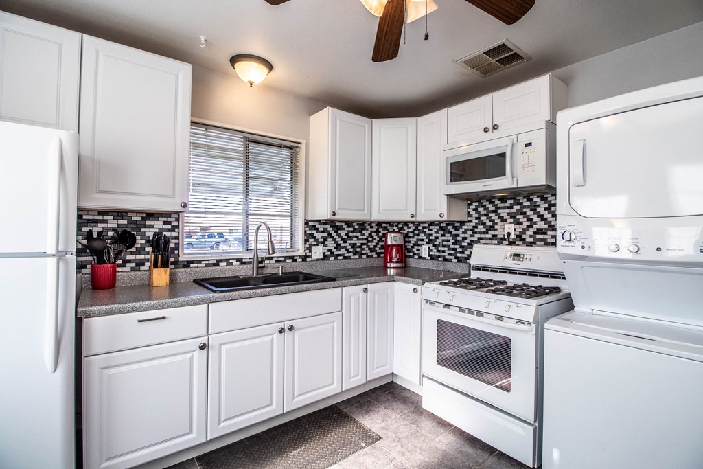 a kitchen with white appliances and white cabinets