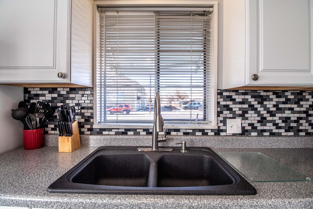 a kitchen sink in front of a window