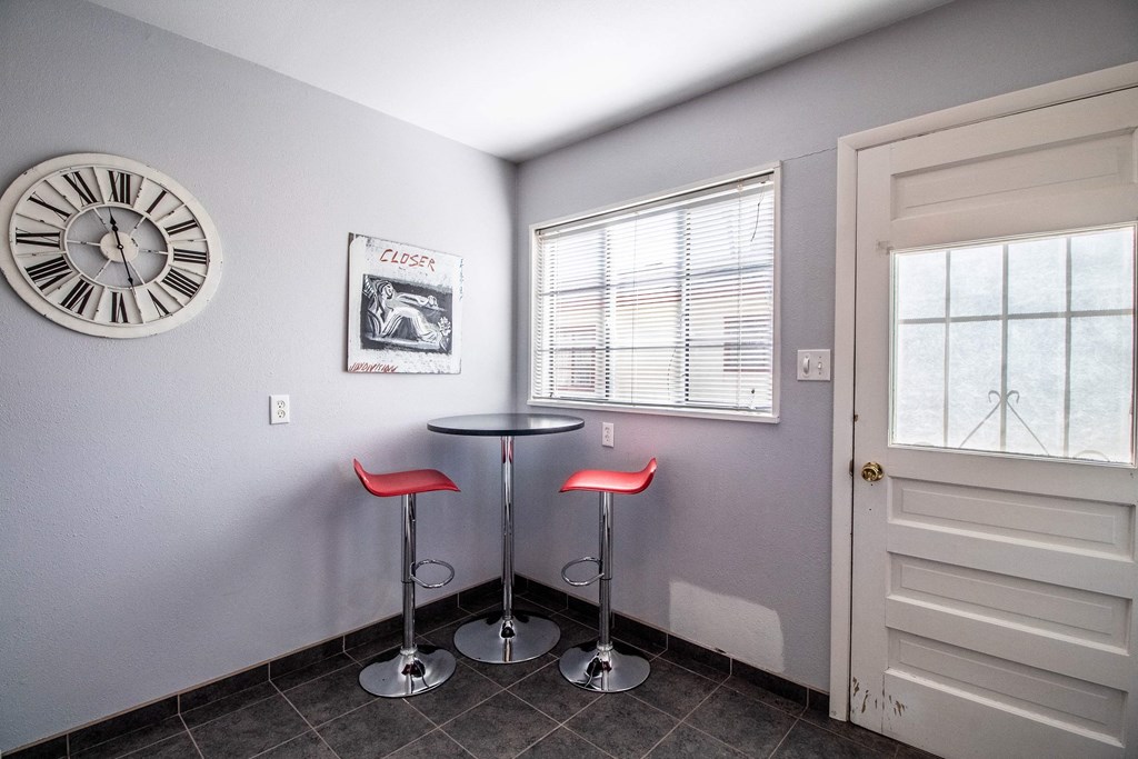 a kitchen with two stools and a clock on the wall
