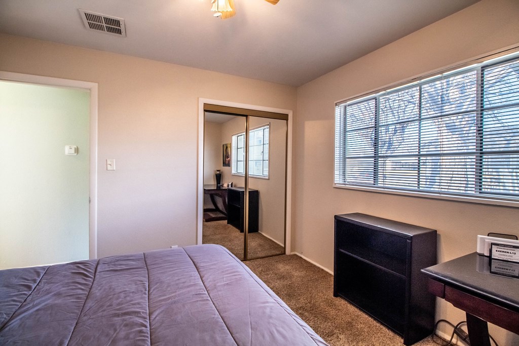 a bedroom with a large window and a large bed