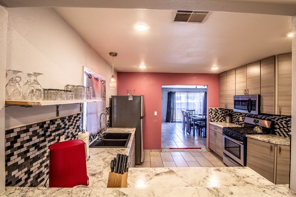 the kitchen is equipped with stainless steel appliances and granite counter tops