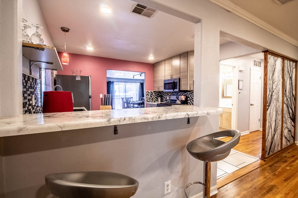 a kitchen with a long counter and a bar with two bowls on it