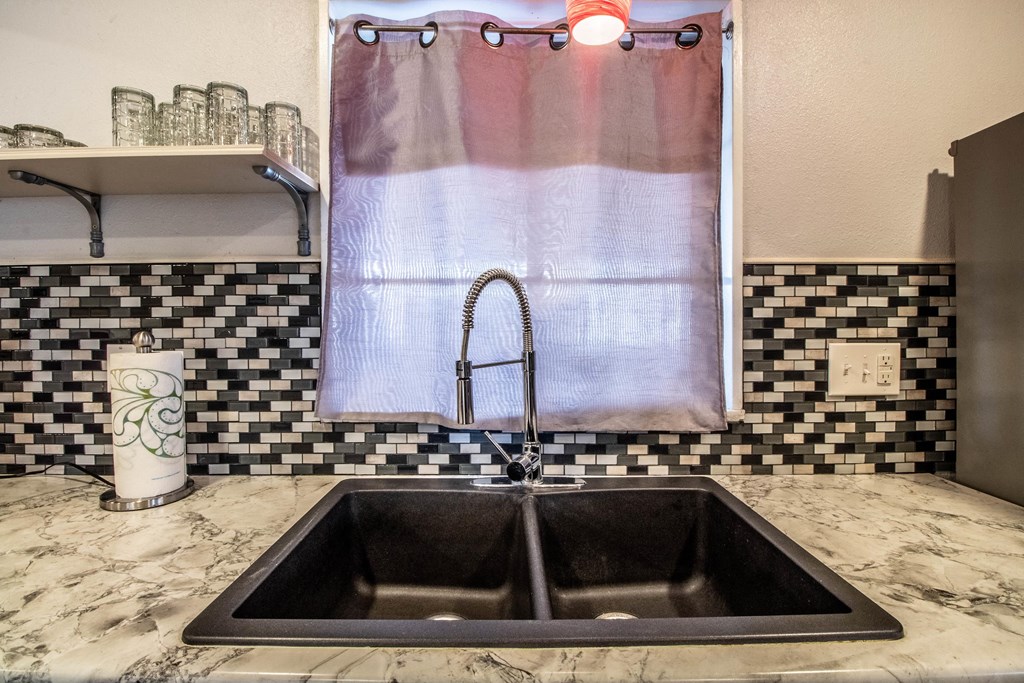 a kitchen with a sink and a shower with a curtain