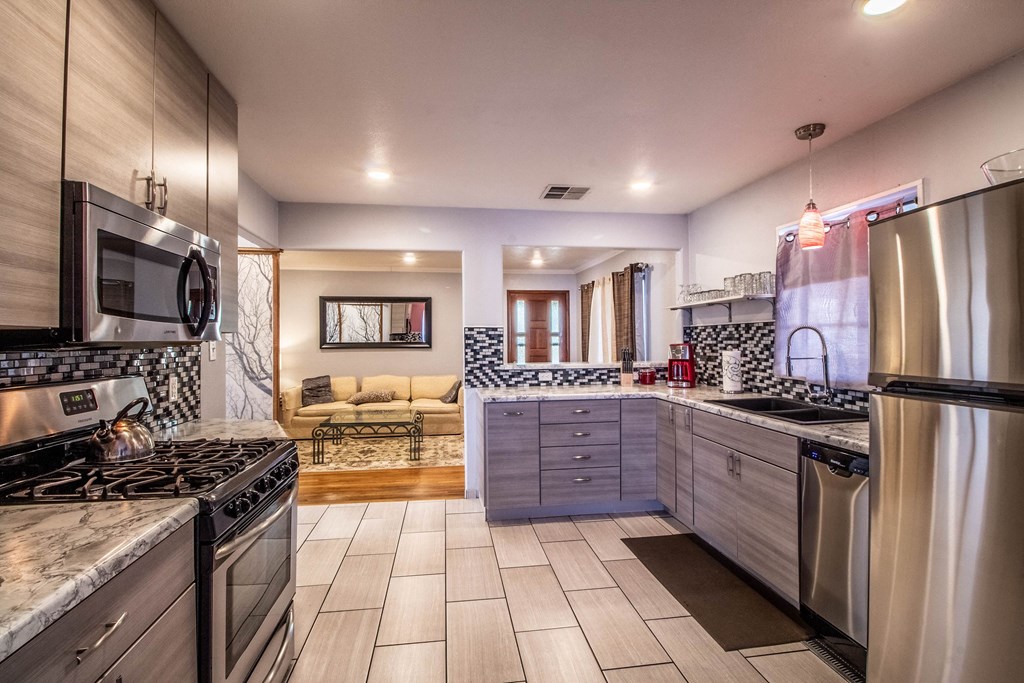 a kitchen with stainless steel appliances and marble counter tops