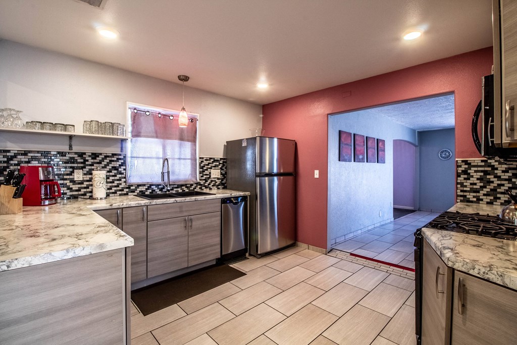 a kitchen with a stainless steel refrigerator and counter tops