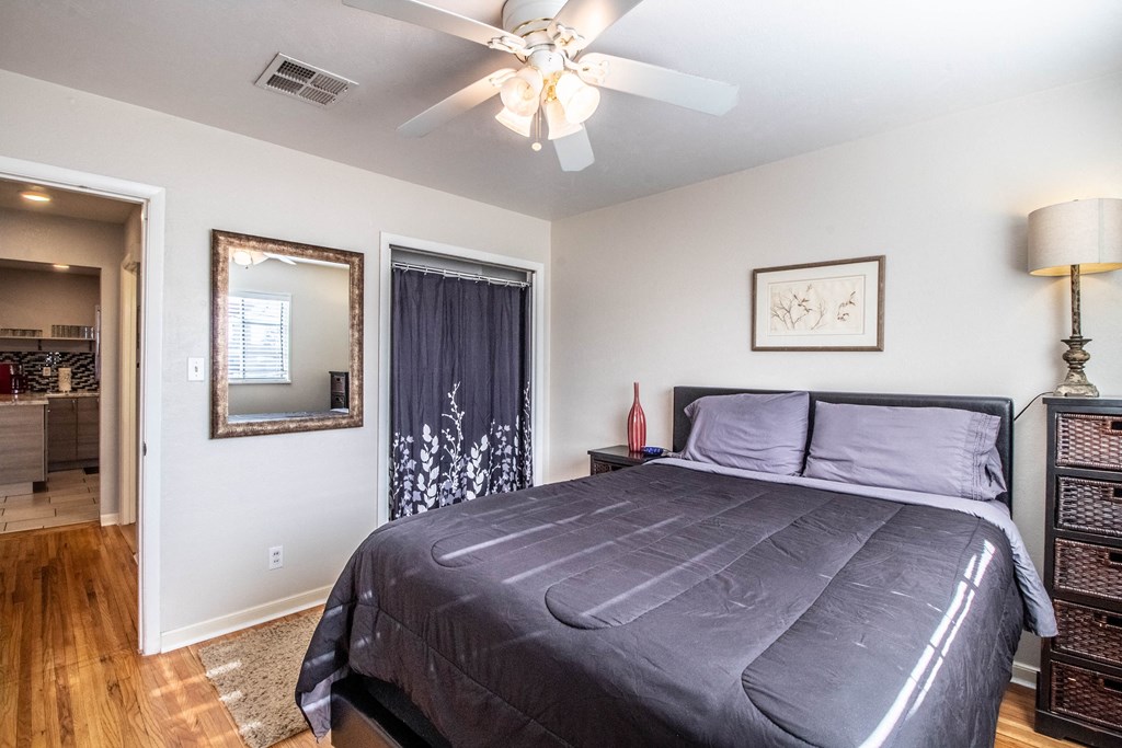 the master bedroom has a large bed and a ceiling fan